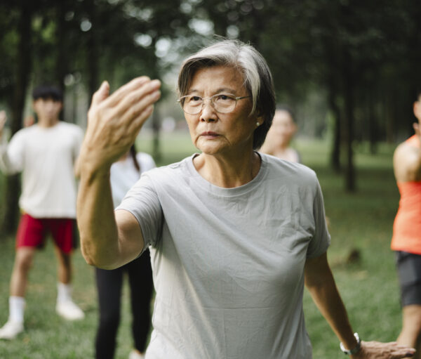 Active senior mother teaching her family Tai Chi.
