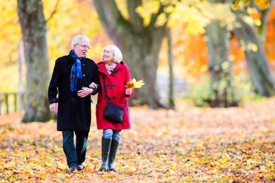 Older couple strolling through park 